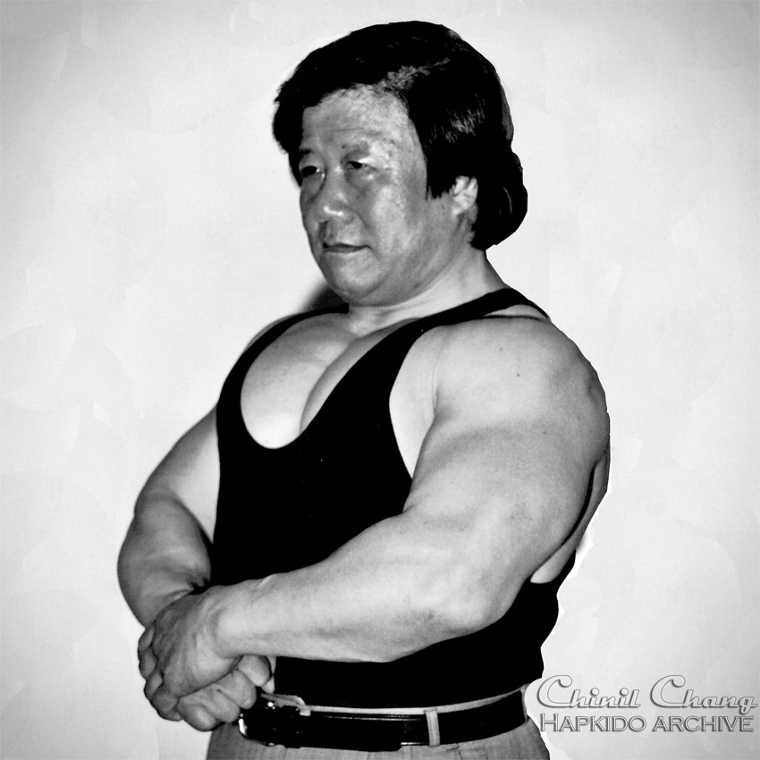 Chang in a flex pose showing the results of his weight training program